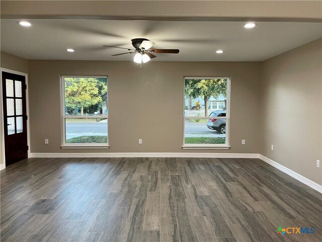 unfurnished room featuring ceiling fan and dark wood-type flooring