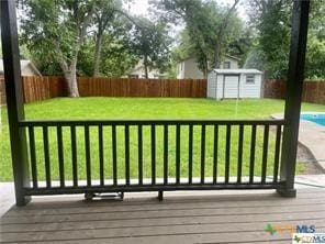 exterior space featuring a lawn, a shed, and a fenced in pool