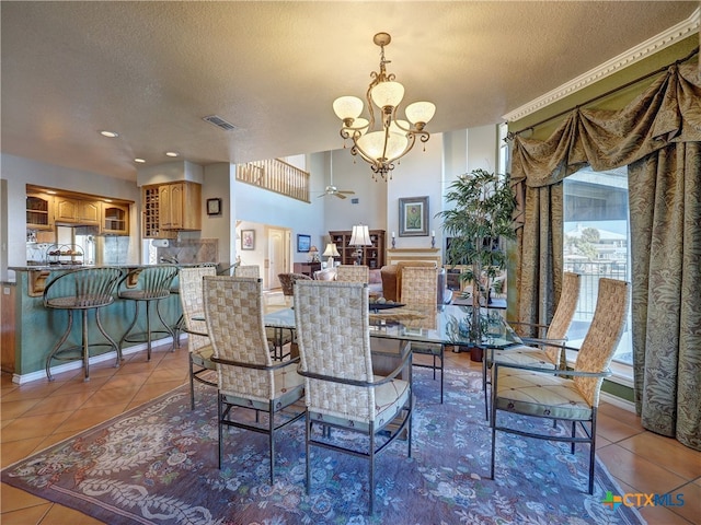 dining space with tile patterned floors, a chandelier, and a textured ceiling