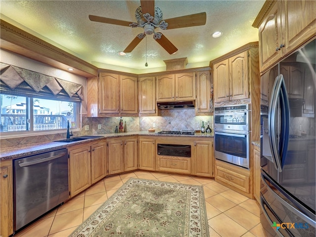 kitchen featuring stainless steel appliances, sink, a textured ceiling, and light tile patterned floors