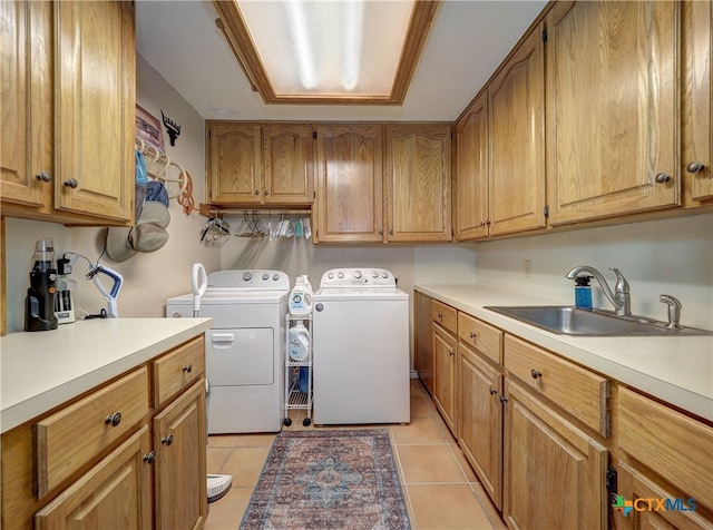 washroom with sink, washer and clothes dryer, cabinets, and light tile patterned flooring