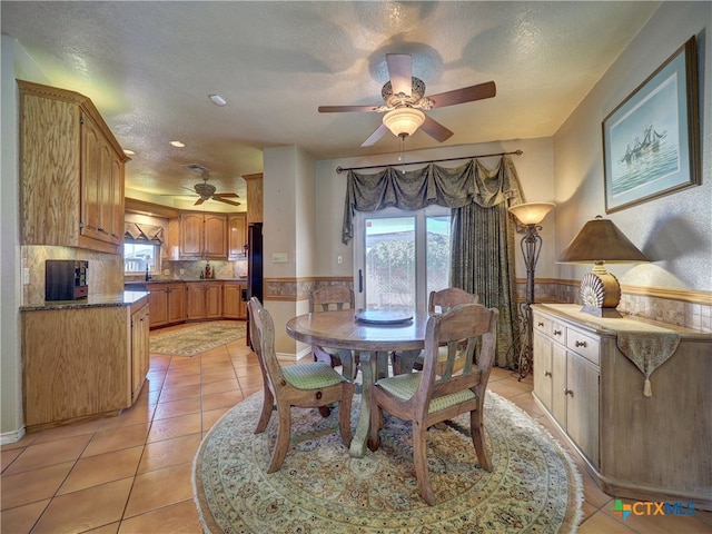 tiled dining room featuring ceiling fan and a textured ceiling