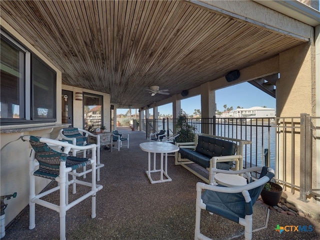 view of patio with ceiling fan and a water view