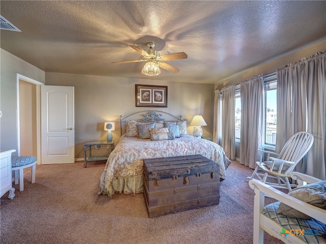 carpeted bedroom with ceiling fan and a textured ceiling