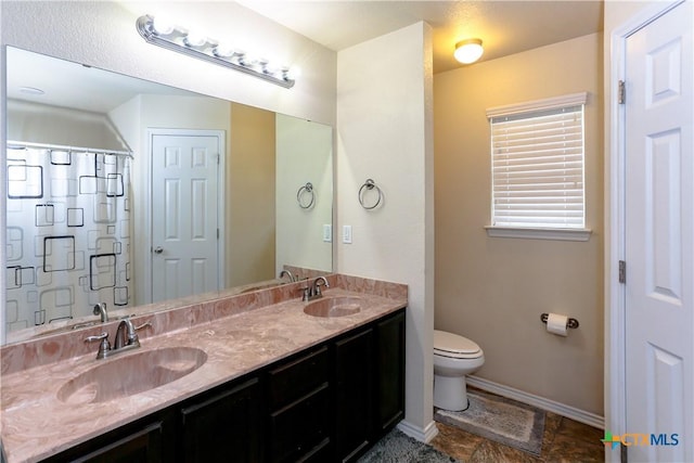 full bath with toilet, a shower with shower curtain, baseboards, and a sink