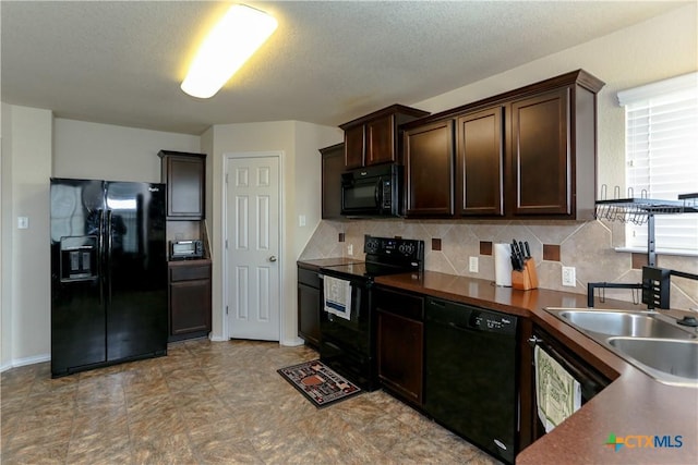 kitchen with dark brown cabinets, a sink, dark countertops, black appliances, and decorative backsplash