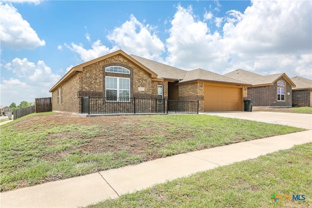 ranch-style home with brick siding, an attached garage, fence private yard, concrete driveway, and a front yard