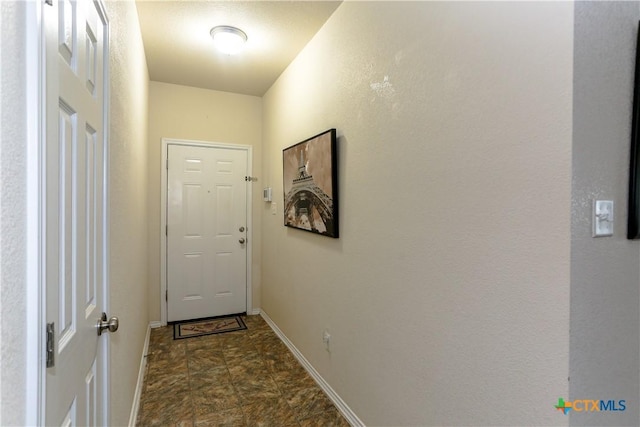 entryway featuring baseboards and stone finish floor