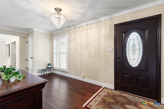 foyer with dark hardwood / wood-style flooring, a notable chandelier, and crown molding