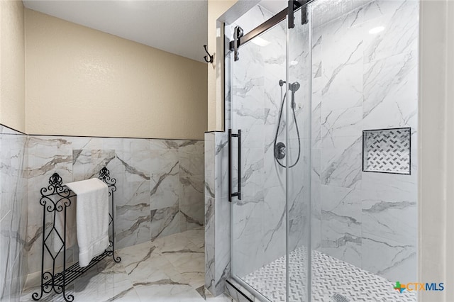 bathroom featuring tile walls and a shower with door