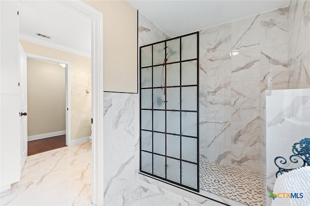 bathroom featuring tiled shower and crown molding