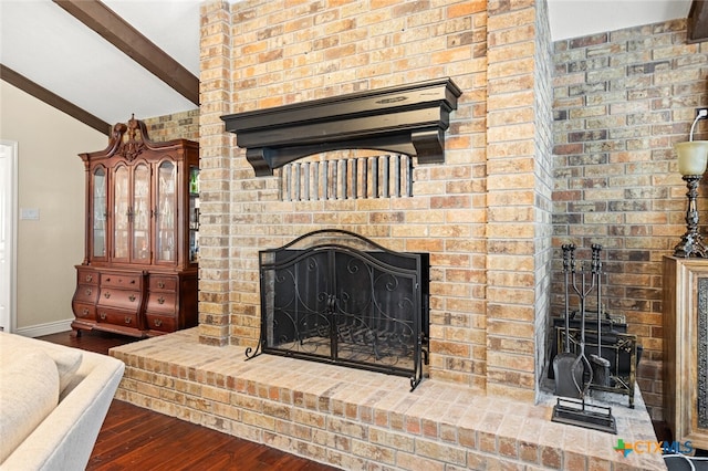 interior details featuring beamed ceiling, wood-type flooring, and a brick fireplace