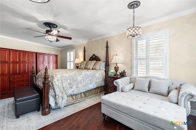 bedroom with dark wood-type flooring, ceiling fan, and crown molding