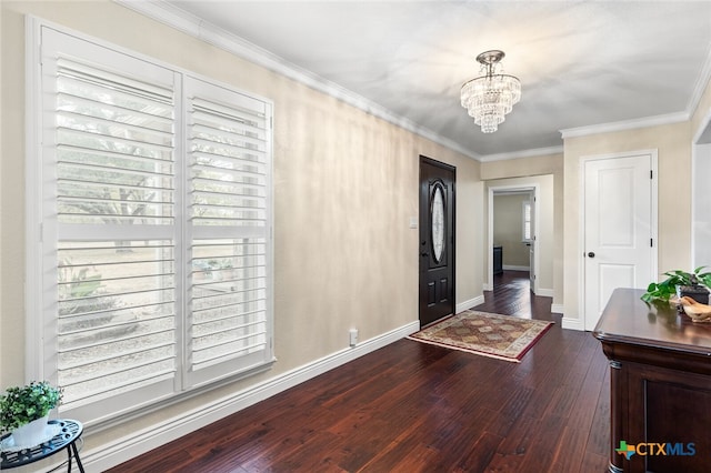 entrance foyer with ornamental molding, a notable chandelier, and dark hardwood / wood-style floors