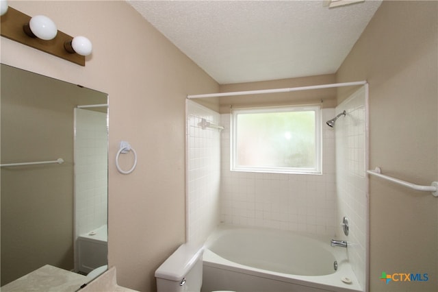 full bathroom with vanity, tiled shower / bath, a textured ceiling, and toilet