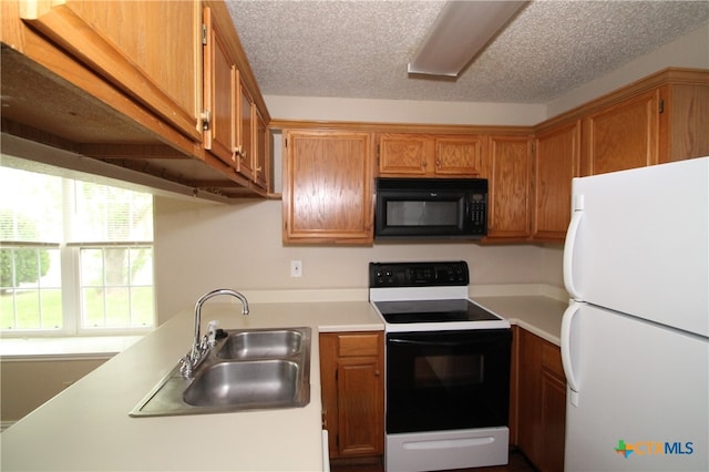 kitchen featuring a textured ceiling, sink, and white appliances