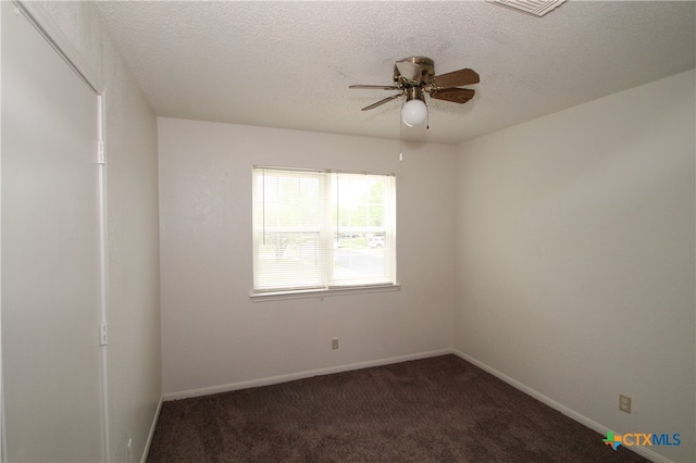 unfurnished room with dark colored carpet, a textured ceiling, and ceiling fan