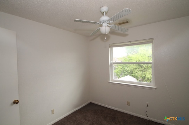 carpeted spare room with a textured ceiling and ceiling fan