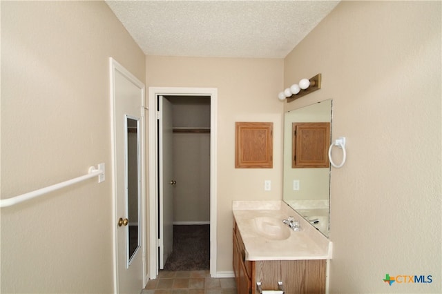 bathroom with tile patterned floors, vanity, and a textured ceiling