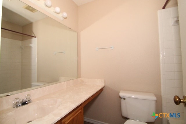 bathroom with walk in shower, vanity, and toilet