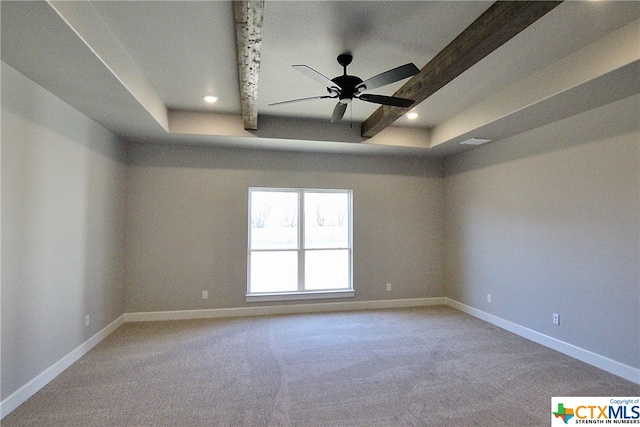 carpeted empty room featuring ceiling fan, beam ceiling, and a tray ceiling