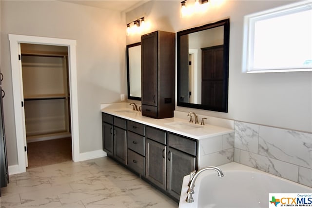 bathroom featuring vanity and a washtub