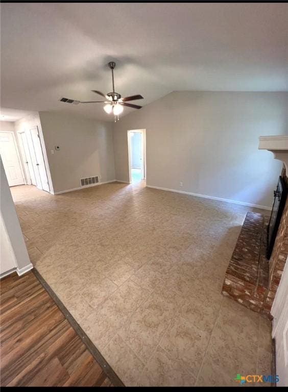 unfurnished living room with ceiling fan, lofted ceiling, and a brick fireplace