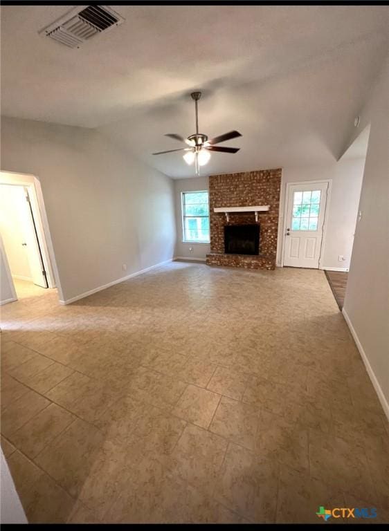 unfurnished living room featuring a fireplace, ceiling fan, plenty of natural light, and vaulted ceiling