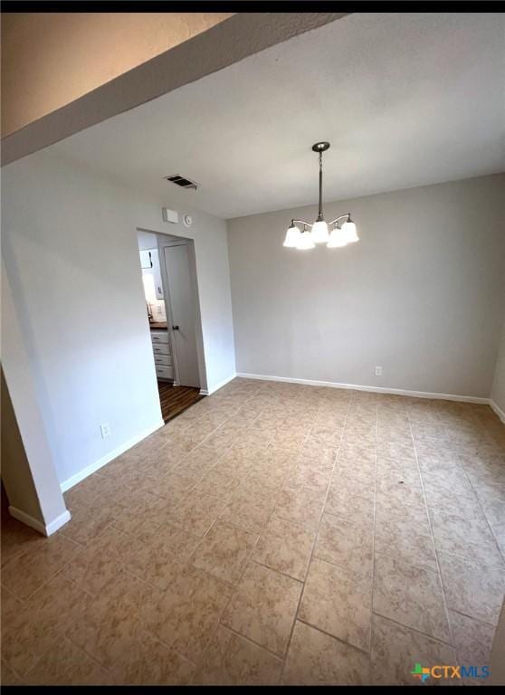 spare room featuring a notable chandelier