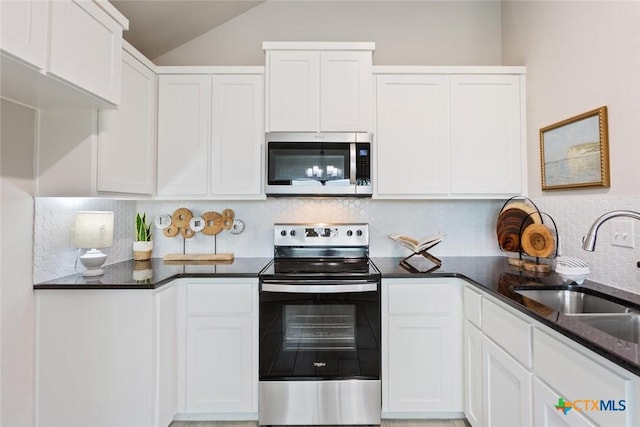 kitchen featuring tasteful backsplash, sink, white cabinets, and appliances with stainless steel finishes