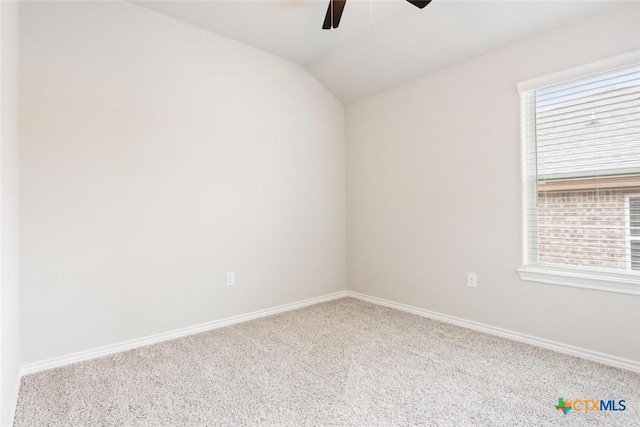 carpeted empty room with ceiling fan, plenty of natural light, and vaulted ceiling