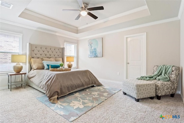 carpeted bedroom featuring ceiling fan, a raised ceiling, and crown molding