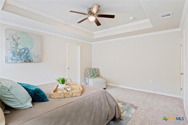 carpeted bedroom with a raised ceiling, ceiling fan, and ornamental molding