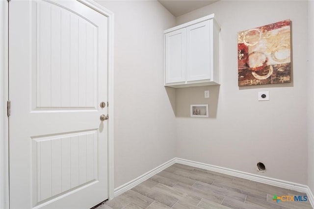 washroom with hookup for an electric dryer, light hardwood / wood-style floors, cabinets, and washer hookup