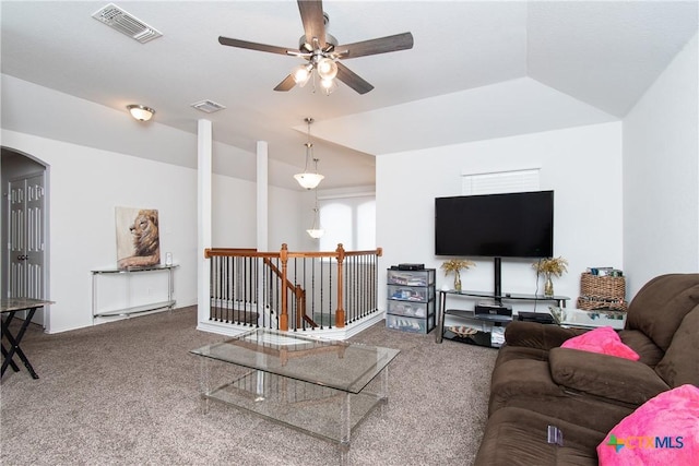 carpeted living room with ceiling fan and vaulted ceiling