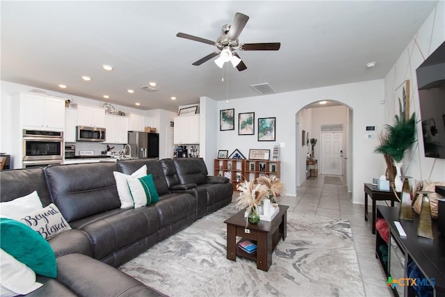 living room featuring ceiling fan, sink, and light tile patterned floors