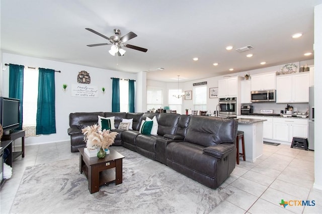 tiled living room with sink, ceiling fan, and a healthy amount of sunlight