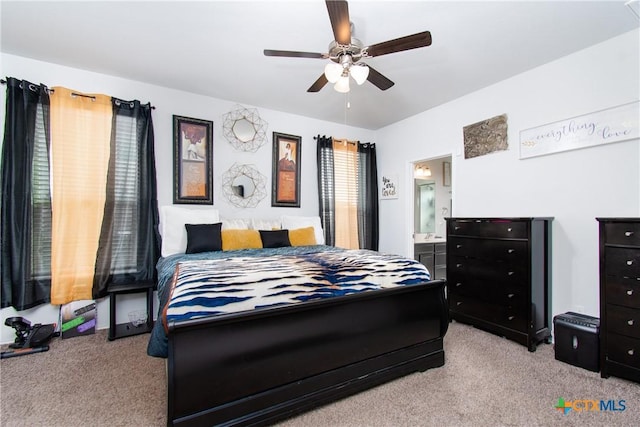 carpeted bedroom with ceiling fan and ensuite bath