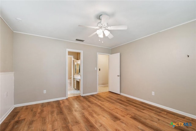1223 N Sarah Dewitt Dr, Gonzales, TX 78629 - unfurnished bedroom with crown molding, wood finished floors, connected bathroom, ceiling fan, and baseboards