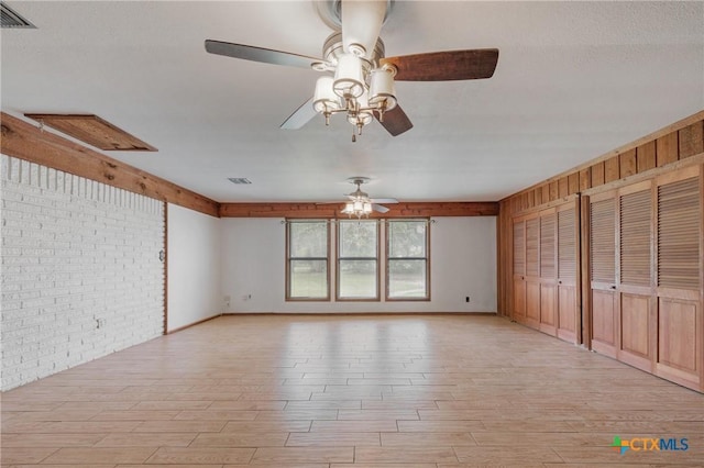 1223 N Sarah Dewitt Dr, Gonzales, TX 78629 - unfurnished bedroom featuring brick wall and light wood-type flooring