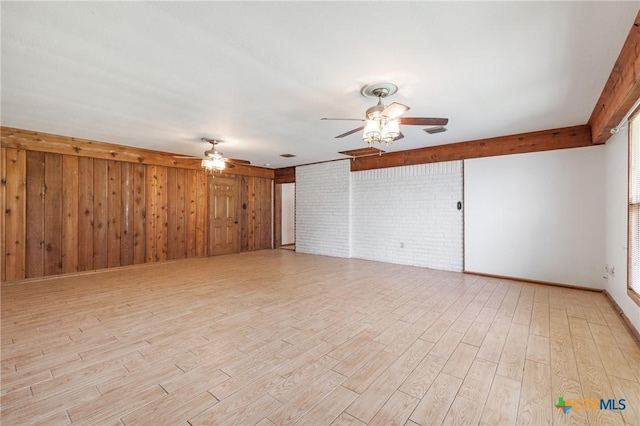 1223 N Sarah Dewitt Dr, Gonzales, TX 78629 - unfurnished living room featuring ceiling fan, light wood-style floors, and wooden walls