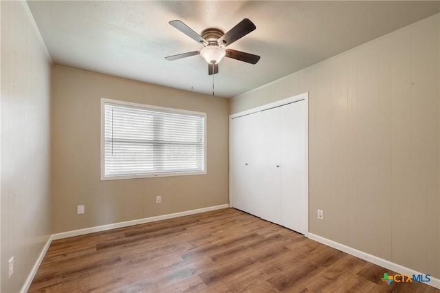 1223 N Sarah Dewitt Dr, Gonzales, TX 78629 - unfurnished bedroom with wood finished floors, a closet, and baseboards