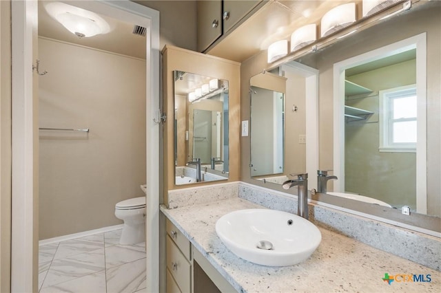1223 N Sarah Dewitt Dr, Gonzales, TX 78629 - bathroom featuring vanity, toilet, marble finish floors, and baseboards