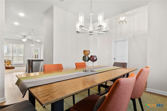 dining room featuring a chandelier, baseboards, wood finished floors, recessed lighting, and ceiling fan