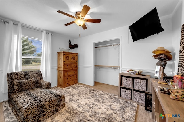 sitting room featuring light colored carpet and ceiling fan