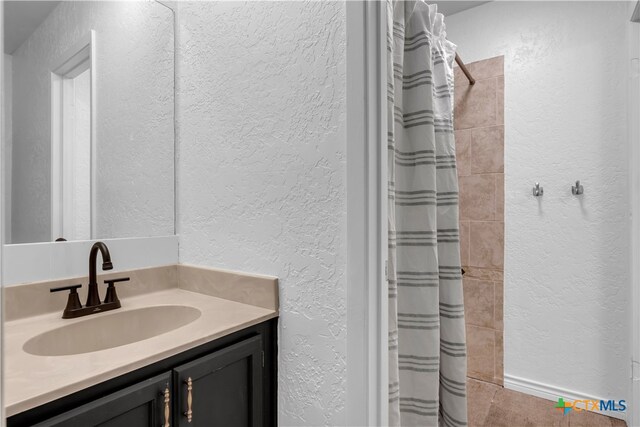 bathroom featuring a shower with curtain and vanity