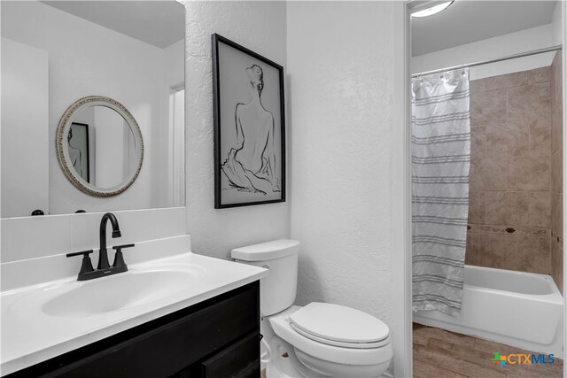 full bathroom with toilet, shower / tub combo, and vanity