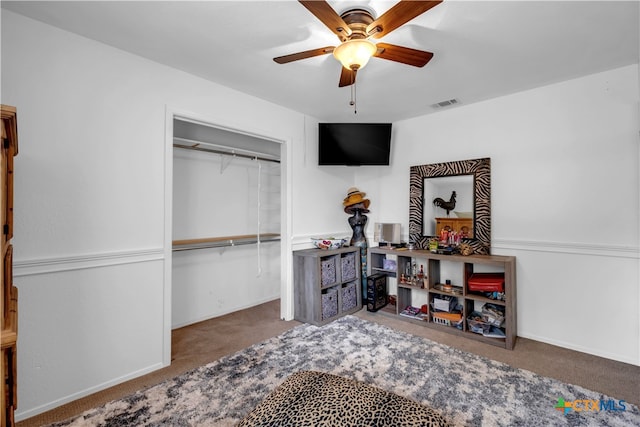 carpeted bedroom featuring ceiling fan and a closet