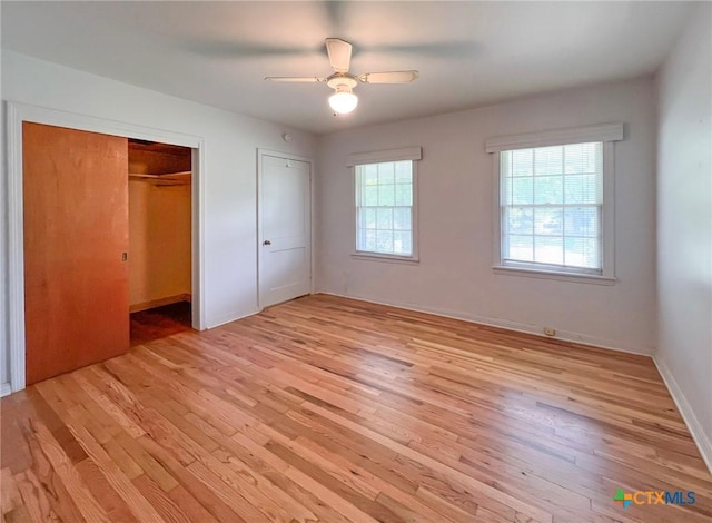 unfurnished bedroom with light wood finished floors, a ceiling fan, multiple closets, and baseboards