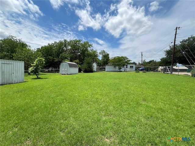 view of grassy yard with a storage unit and an outdoor structure